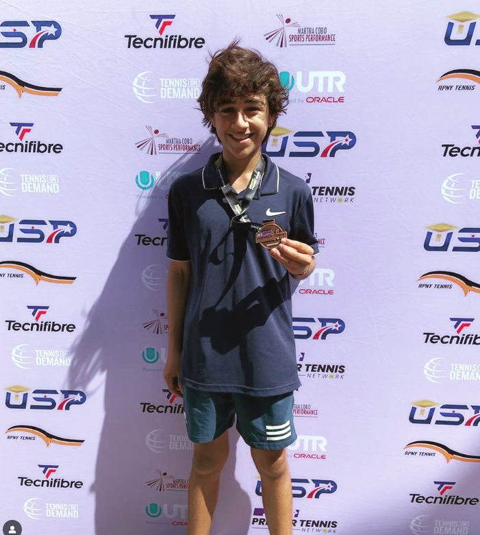 Oscar B. with tournament trophy — NMBA junior tennis champion