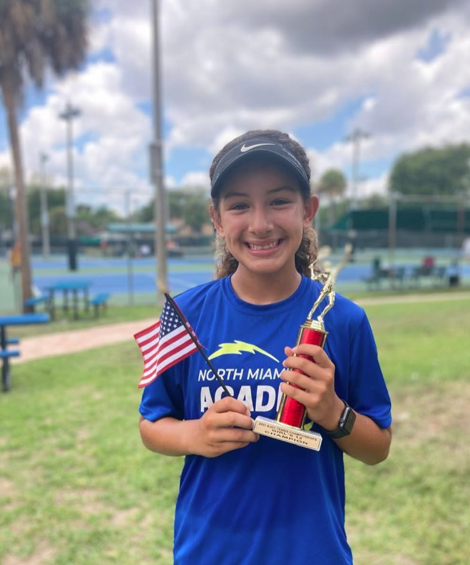 Michelle P. celebrating tournament win — NMBA junior tennis success story