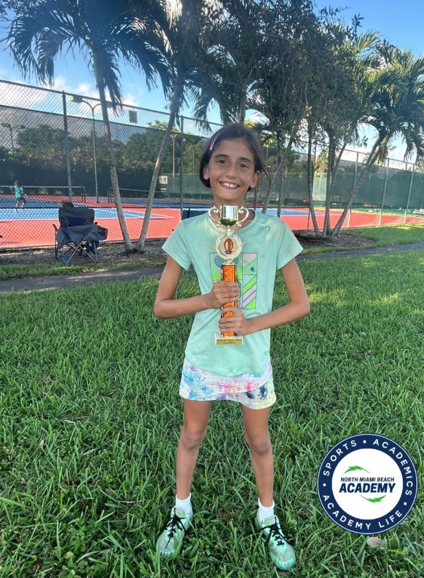 Ayana Schecker with tournament trophy — NMBA junior tennis success story
