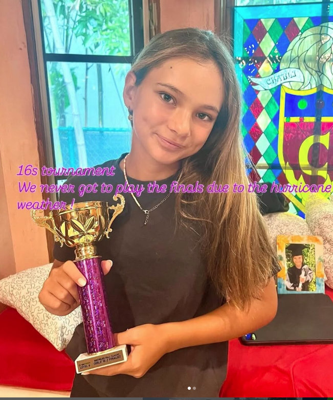 Nina C. with championship trophy — NMBA junior tennis success story