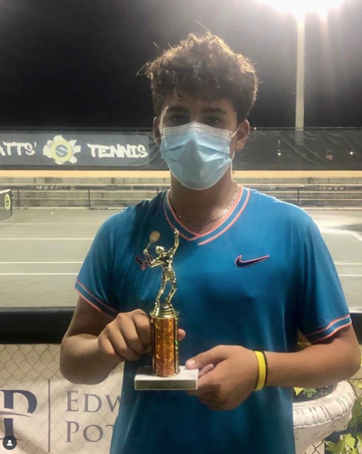 Luca B. with championship trophy — NMBA junior tennis tournament winner